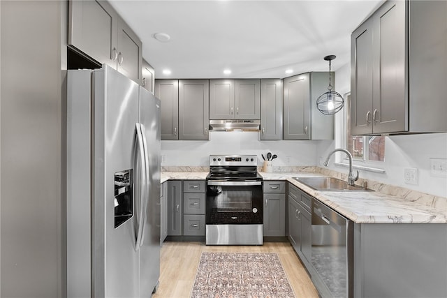 kitchen with stainless steel appliances, sink, light hardwood / wood-style flooring, gray cabinets, and hanging light fixtures