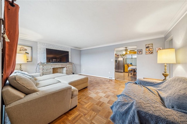 living room featuring ceiling fan, ornamental molding, a fireplace, and light parquet flooring