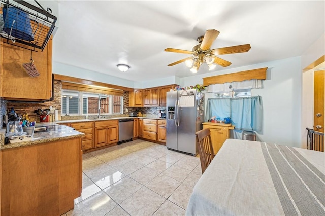 kitchen featuring sink, ceiling fan, light tile patterned floors, tasteful backsplash, and stainless steel appliances