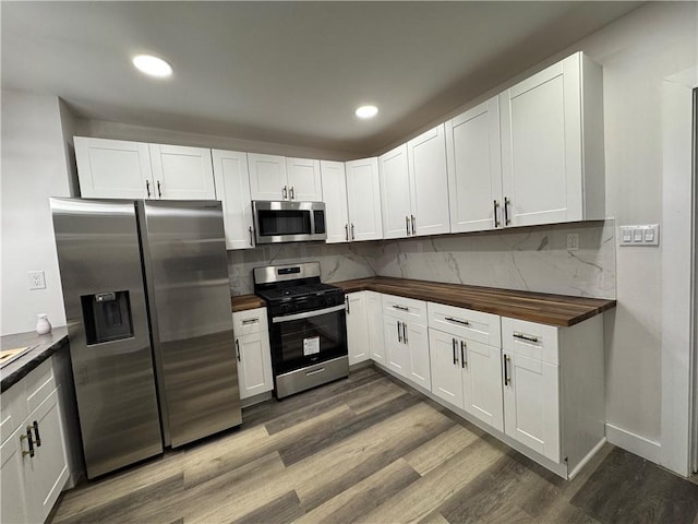 kitchen with white cabinets, dark hardwood / wood-style floors, and appliances with stainless steel finishes