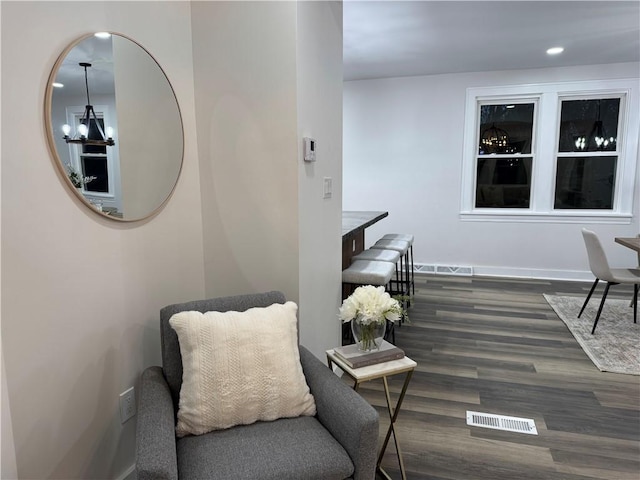 living area featuring dark wood-type flooring and a notable chandelier