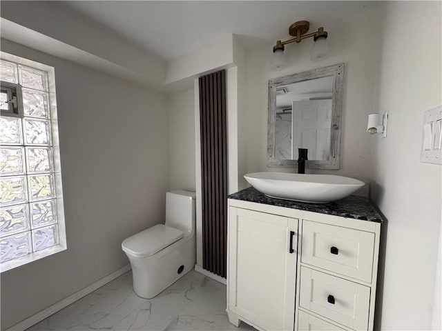 bathroom featuring vanity, toilet, and a wealth of natural light