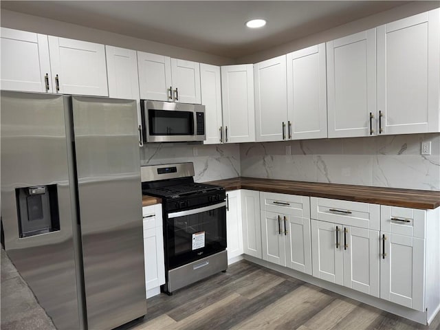 kitchen with wooden counters, stainless steel appliances, white cabinetry, and dark hardwood / wood-style floors