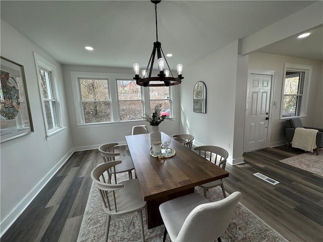 dining space featuring plenty of natural light, dark wood-type flooring, and a notable chandelier