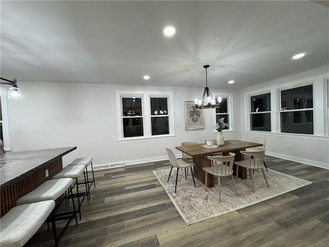 dining space featuring a chandelier and dark wood-type flooring