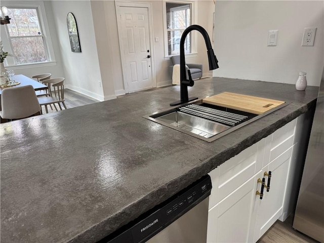 kitchen featuring hardwood / wood-style floors, sink, white cabinets, and a healthy amount of sunlight