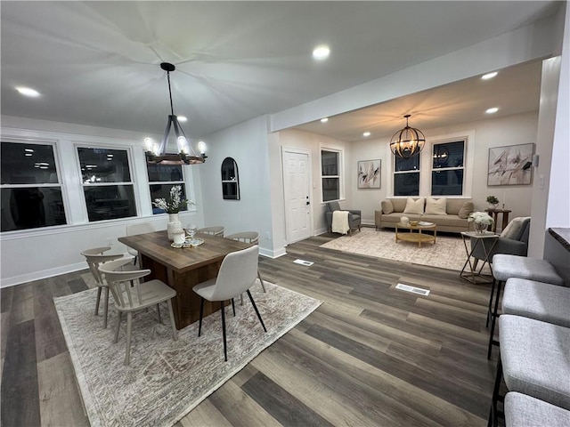 dining space with dark hardwood / wood-style flooring and a notable chandelier