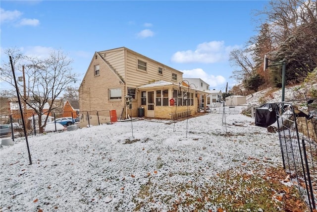 snow covered property featuring a sunroom