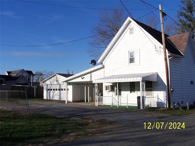 view of front facade with an outbuilding, a porch, and a garage