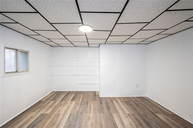 basement with a paneled ceiling and hardwood / wood-style flooring