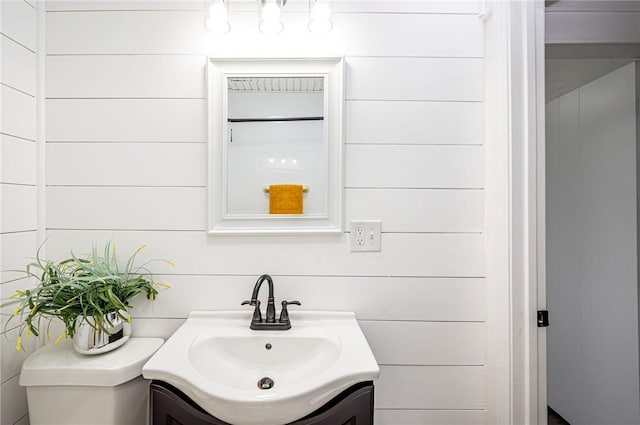 bathroom with vanity and wooden walls