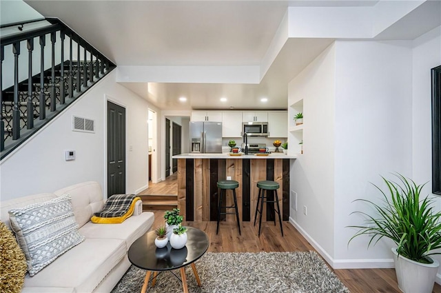 living room featuring hardwood / wood-style floors and sink