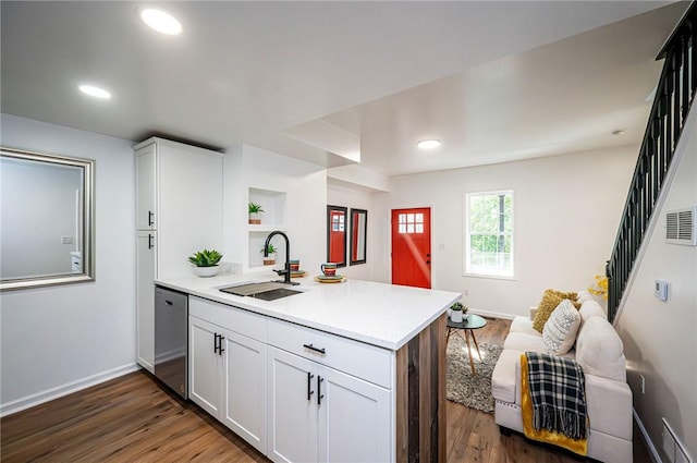 kitchen with dark wood-type flooring, white cabinetry, stainless steel dishwasher, and sink