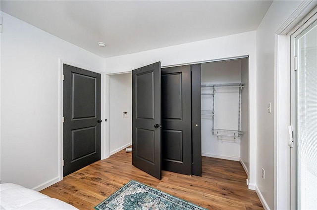 bedroom with a closet and hardwood / wood-style flooring