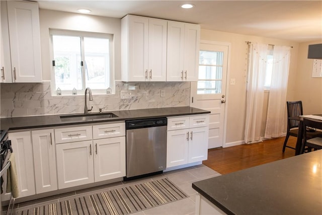 kitchen featuring decorative backsplash, white cabinetry, sink, and appliances with stainless steel finishes