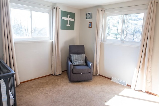 sitting room with a wealth of natural light and light carpet