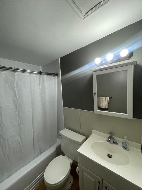 full bathroom featuring shower / bath combo with shower curtain, vanity, and toilet