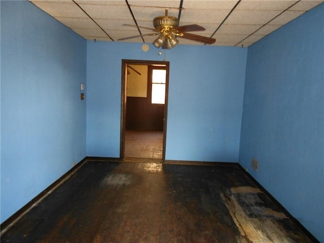 spare room featuring a paneled ceiling, ceiling fan, and dark hardwood / wood-style floors