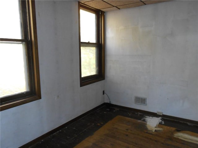 spare room with a drop ceiling and a wealth of natural light