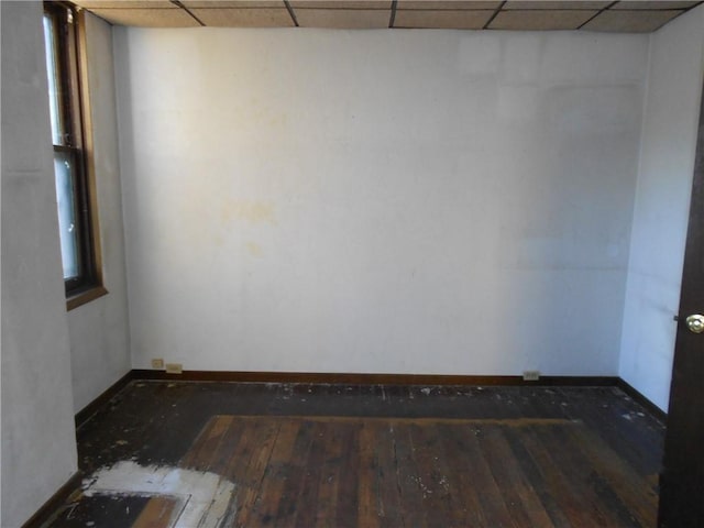 unfurnished room featuring wood-type flooring and a drop ceiling