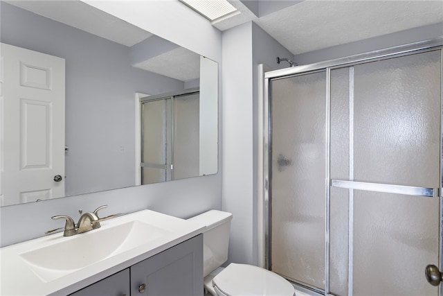 bathroom featuring an enclosed shower, vanity, toilet, and a textured ceiling