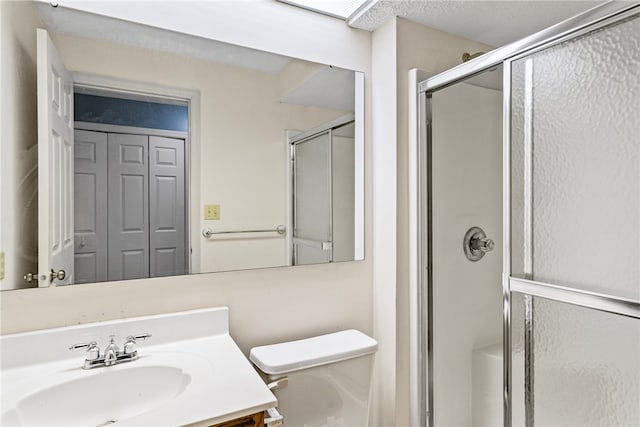 bathroom with toilet, walk in shower, and vanity