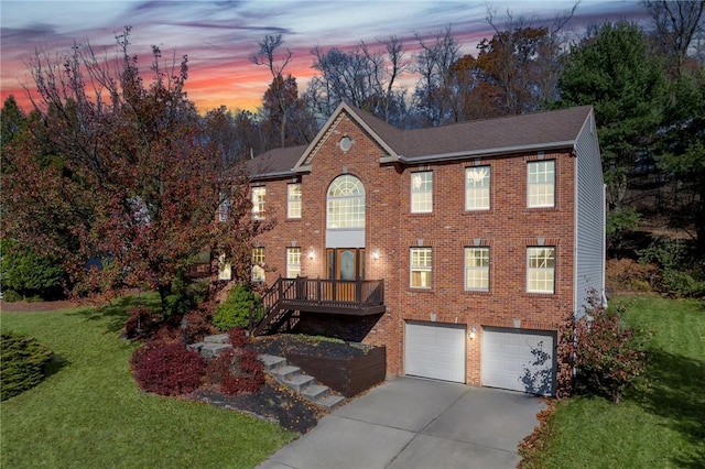 colonial home with a lawn, a deck, and a garage