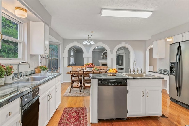 kitchen featuring sink, pendant lighting, stainless steel appliances, and white cabinetry