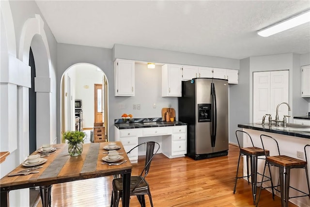 kitchen featuring sink, white cabinetry, light hardwood / wood-style flooring, and stainless steel appliances