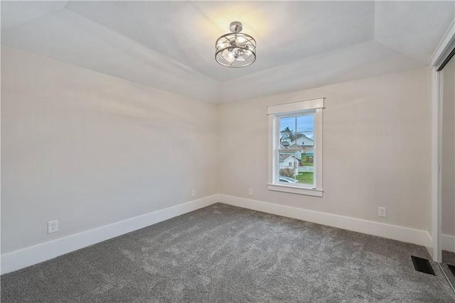 carpeted spare room with vaulted ceiling