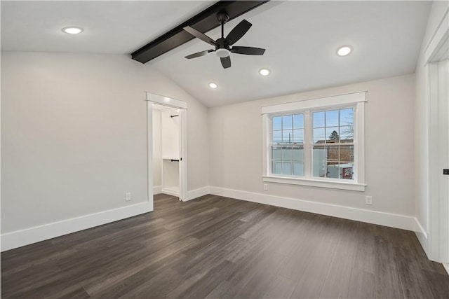 unfurnished bedroom featuring vaulted ceiling with beams, dark hardwood / wood-style floors, ceiling fan, and a walk in closet