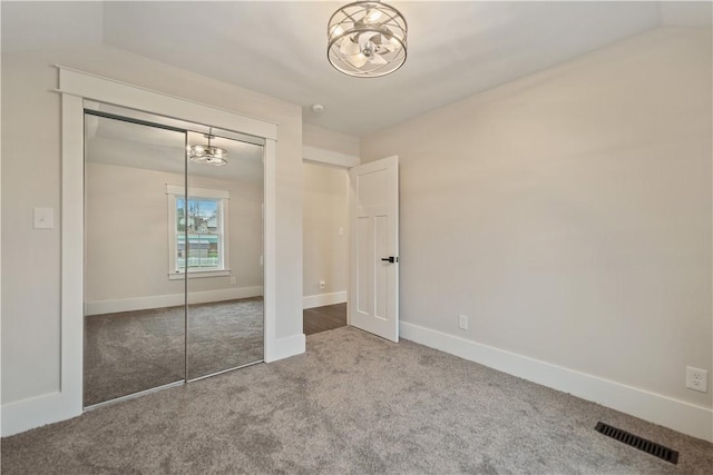 unfurnished bedroom with a closet, carpet, and lofted ceiling