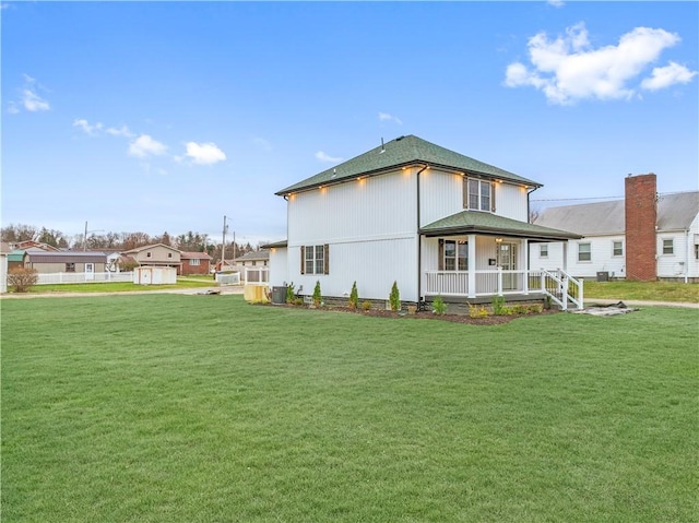 rear view of property with a lawn and covered porch