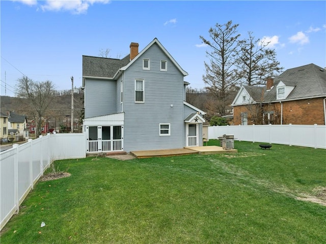 back of house with a wooden deck and a yard