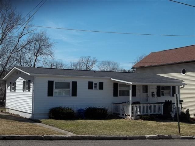 view of front of property with a porch and a front lawn