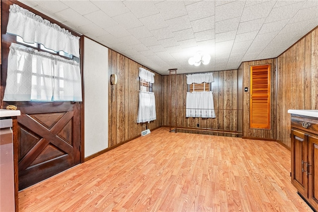 spare room featuring wooden walls and light hardwood / wood-style flooring