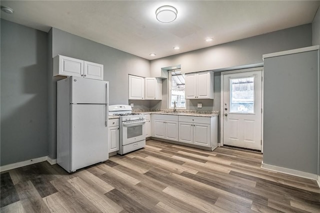 kitchen with white cabinets, white appliances, light hardwood / wood-style flooring, and sink