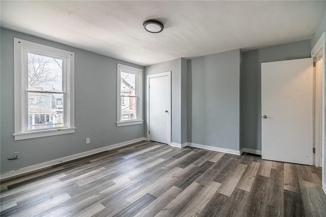 unfurnished bedroom featuring a closet and dark wood-type flooring