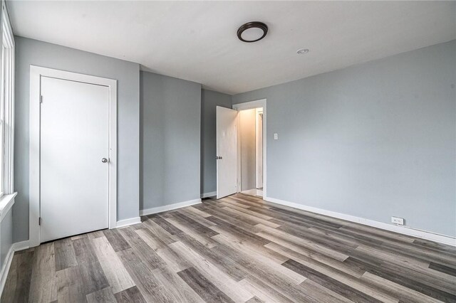 unfurnished bedroom with hardwood / wood-style floors and a closet