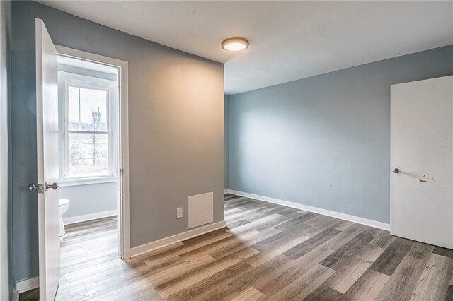 spare room with wood-type flooring