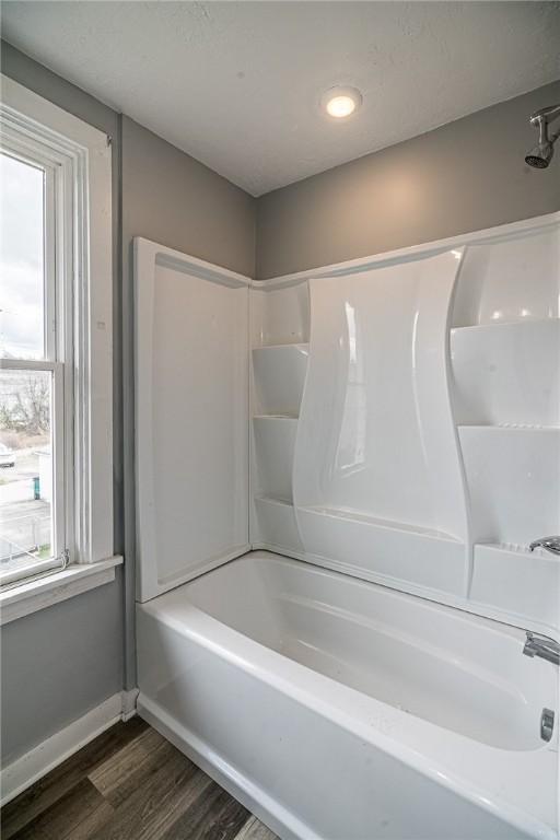 bathroom with hardwood / wood-style floors and  shower combination