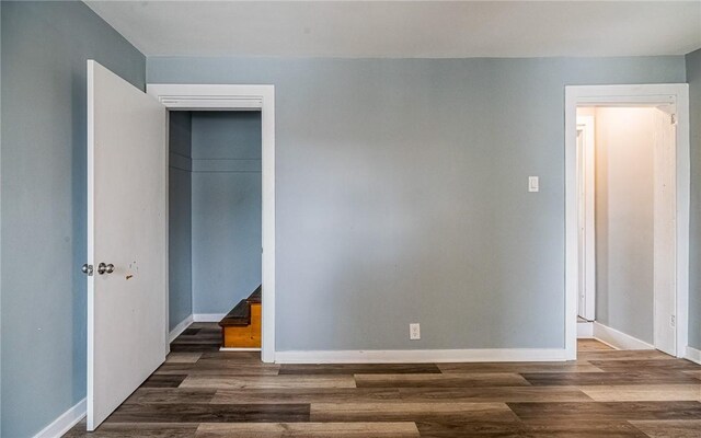 unfurnished bedroom featuring a closet and dark hardwood / wood-style flooring