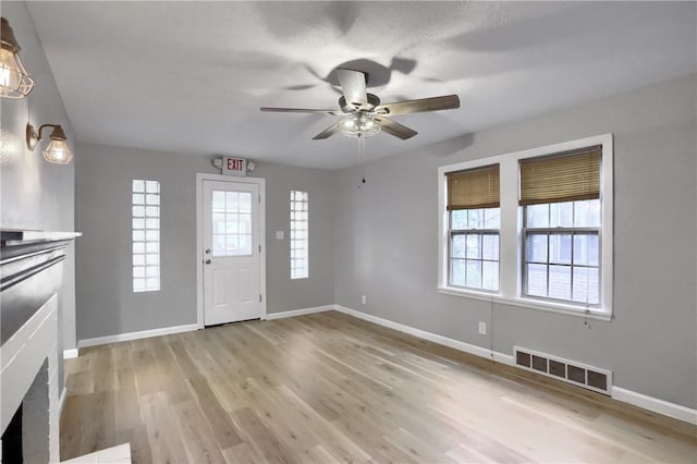 foyer with ceiling fan and light hardwood / wood-style floors