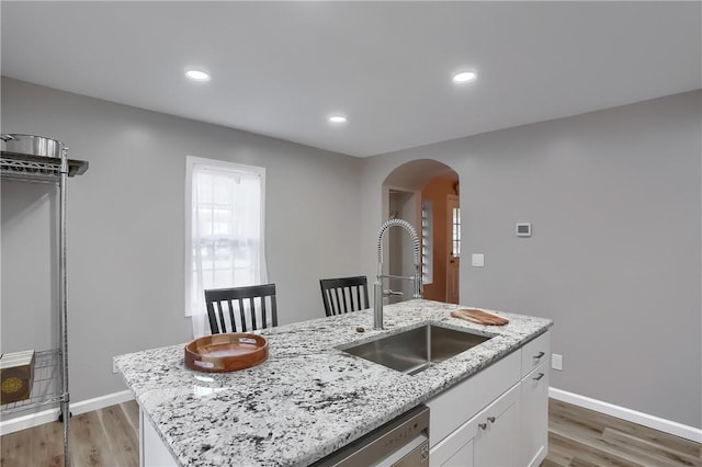 kitchen with a center island with sink, dark hardwood / wood-style floors, white cabinetry, and sink