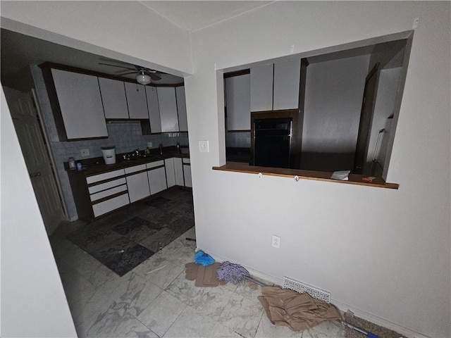 kitchen with ceiling fan, sink, backsplash, oven, and gray cabinets