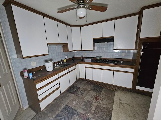 kitchen with tasteful backsplash, white cabinetry, and sink