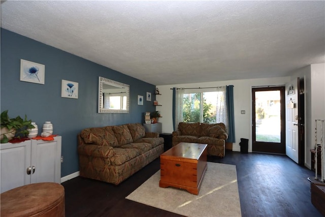 living room featuring a textured ceiling and dark hardwood / wood-style floors