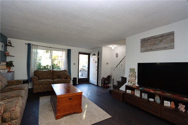 living room with dark hardwood / wood-style flooring and a textured ceiling