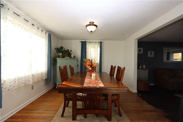 dining space featuring plenty of natural light and dark hardwood / wood-style flooring