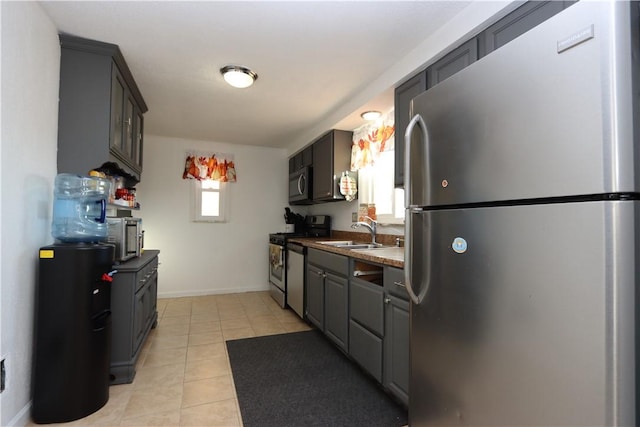 kitchen with sink, light tile patterned floors, and stainless steel appliances